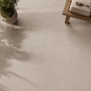 Vloertegel New Tiles Etna Beige 100x100 cm bovenaanzicht met plant en houten bank